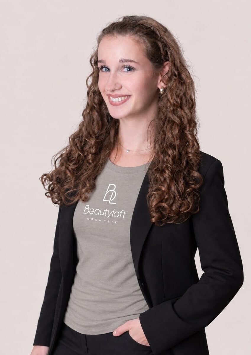 Luisa mit langen Locken im Beautyloft-Shirt und schwarzem Blazer