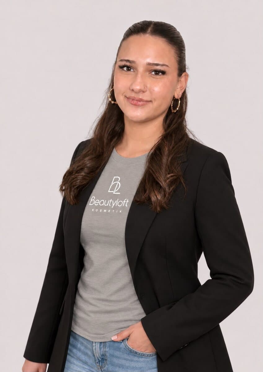 Mitarbeiterin des Beautyloft-Teams mit langem, dunklem Haar im Beautyloft-Shirt und schwarzem Blazer