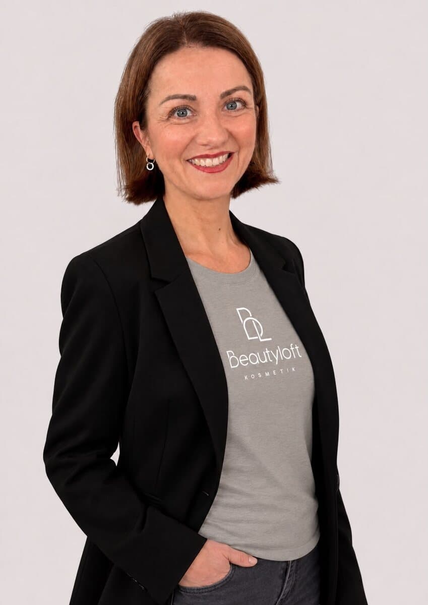 Mitarbeiterin des Beautyloft-Teams mit kurzem Haar im Beautyloft-Shirt und schwarzem Blazer